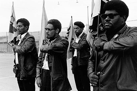 Four men stand and hold Panther flags (Photo: Pirkle Jones and Ruth-Marion Baruch)