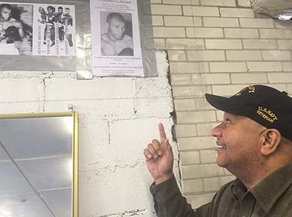 Rev. John Roberts proudly points to pictures of his dad, boxing champion Harold Johnson on the wall of the recreation center that now bears his name in his neighborhood of Manayunk-Roxborough. (Photo: Chris Murray)