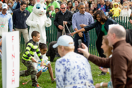 President Barack Obama, joined by the Easter Bunny, and first lady Michelle Obama, cheers children on during the White House Easter Egg Roll on the South Lawn at the White House in Washington, Monday, March 28, 2016. Thousands of children gathered at the White House for the annual Easter Egg Roll which features live music, sports courts, cooking stations, storytelling, and Easter egg rolling. (AP Photo/Andrew Harnik)