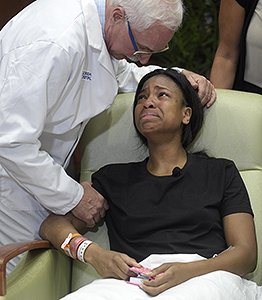 Patience Carter, of Philadelphia, a victim in the Pulse nightclub shooting, is comforted by Dr. Neil Finkler after speaking during a news conference at Florida Hospital Orlando Tuesday, June 14, 2016, in Orlando, Fla. (AP Photo/Phelan M. Ebenhack)