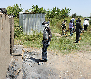In this photo taken Tuesday, Nov. 15, 2016, a man collecting bodies to bury in a mass grave approaches a burned hut containing charred corpses, on the outskirts of Yei, in southern South Sudan. The formerly peaceful town of Yei, surrounded by farms in southern South Sudan was once a beacon of coexistence, but Yei is now a centre of the country's renewed civil war and it gripped by a wave of killings among the dozens of ethnic groups. (AP Photo/Justin Lynch)